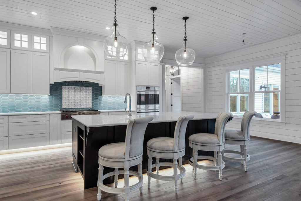 a large kitchen with white cabinets and a center island