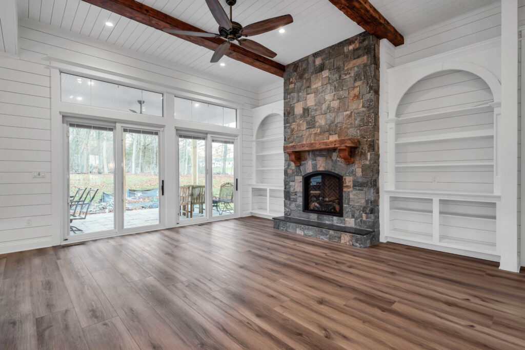 a living room with a fireplace and a ceiling fan