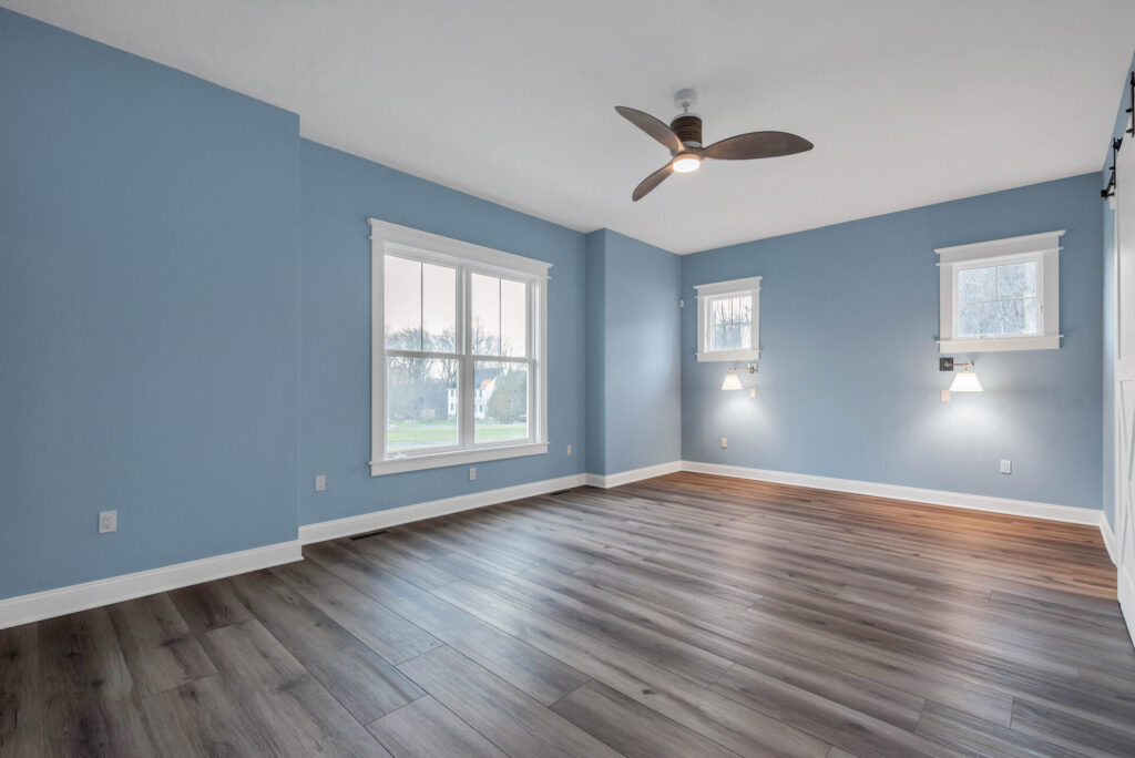 an empty living room with blue walls and wood floors