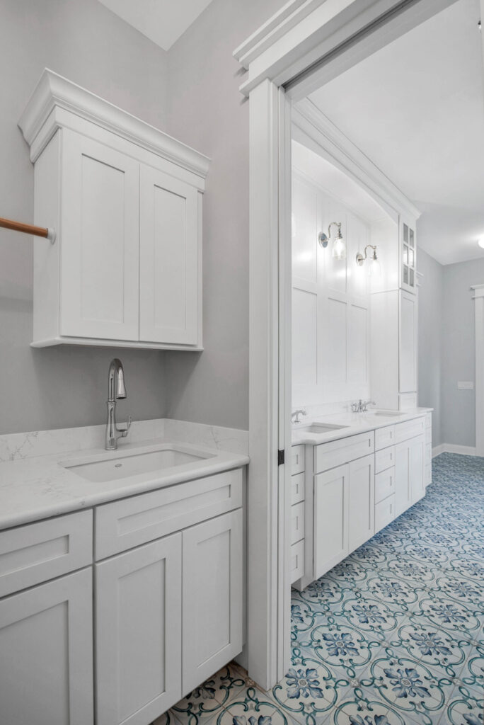 a kitchen with a sink, cabinets, and blue carpet