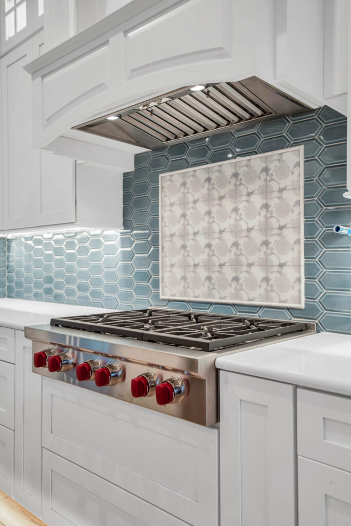 a kitchen with white cabinets and a stainless steel range hood