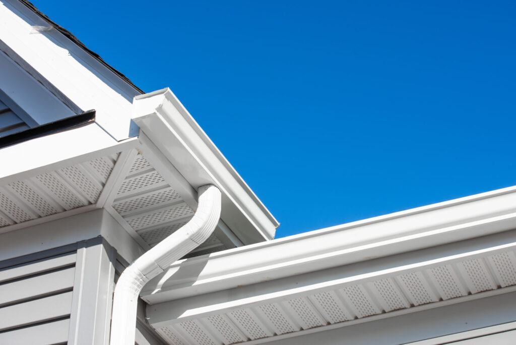 View of the corner of a home with newly installed gutters and gutter guards.